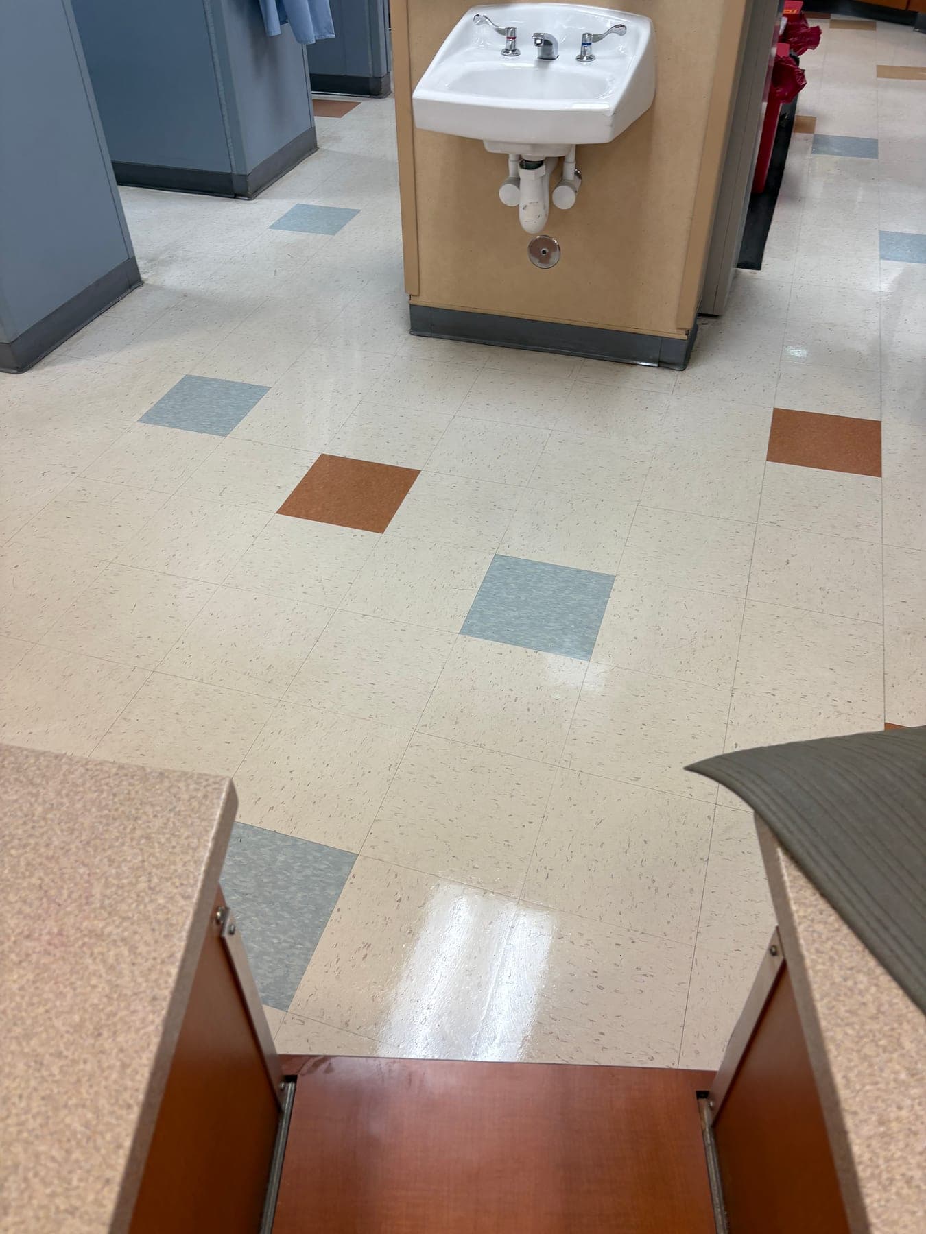 Medical office corridor with a wall sink and freshly finished tile floor