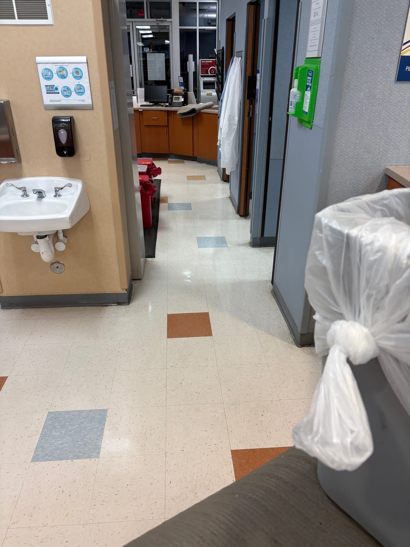 Empty medical office corridor with a freshly finished tile floor, cleaned after hours