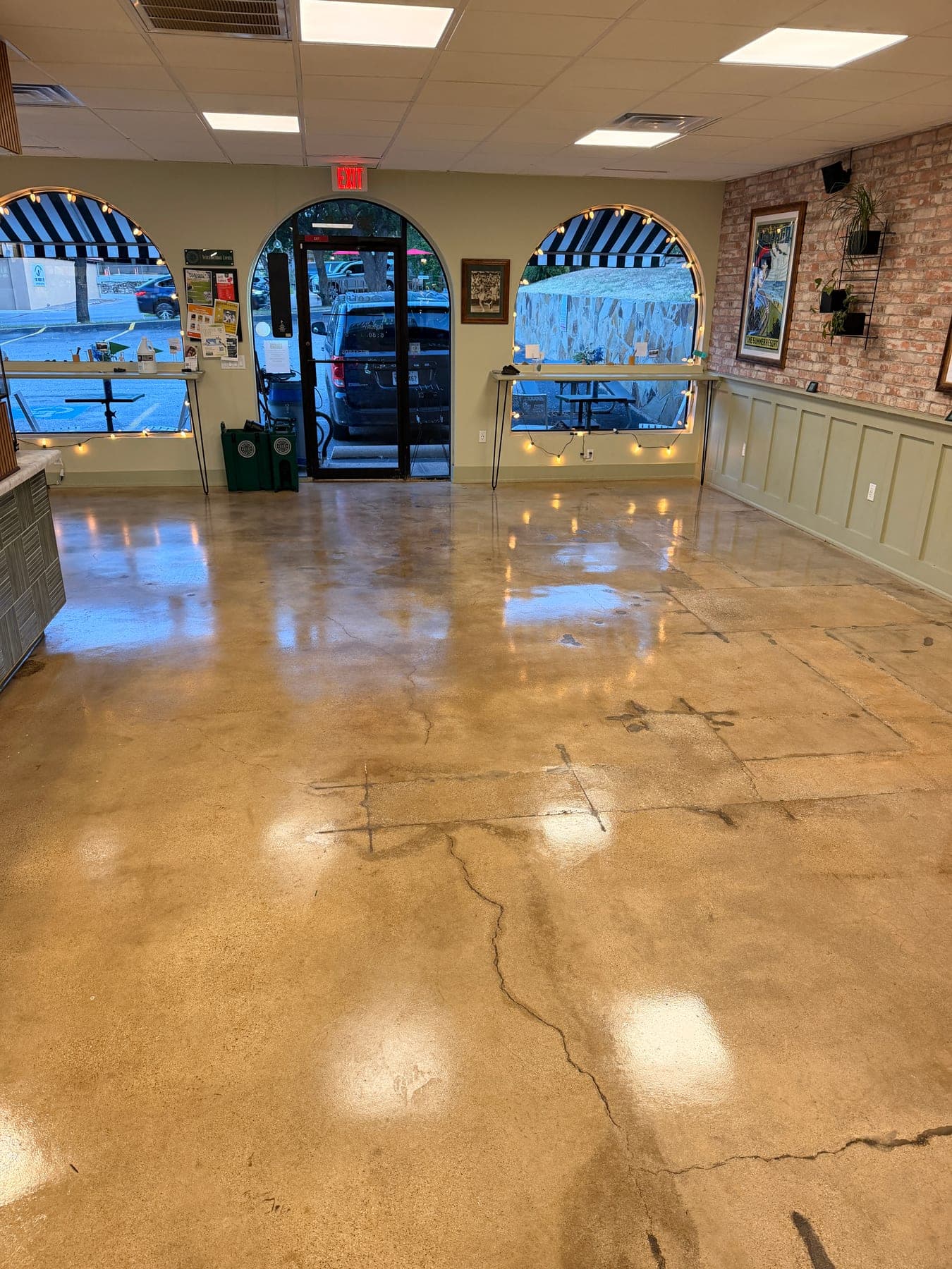Café concrete floor by the arched windows after stripping, degreasing and resealing to a gloss