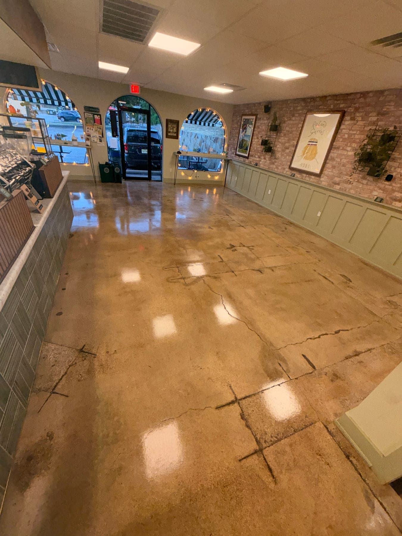 The same cafe entrance after polishing, with a reflective floor