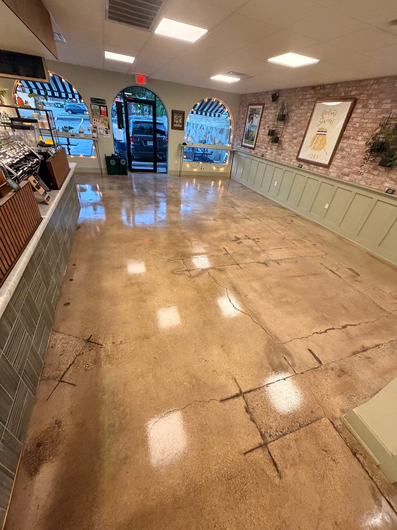 The same cafe dining room after stripping, degreasing and resealing, the floor reflecting the ceiling lights