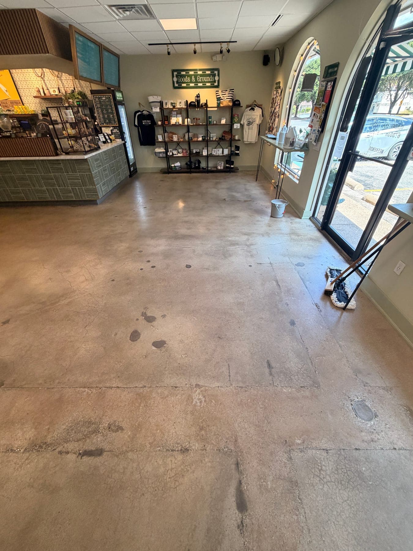 Stained concrete floor at a cafe entrance before cleaning