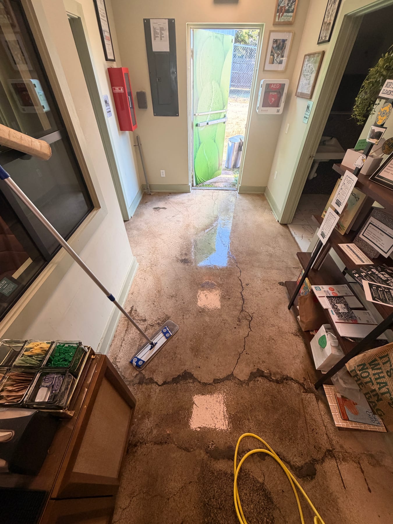 Café corridor during cleaning with a hose out and the concrete floor wet