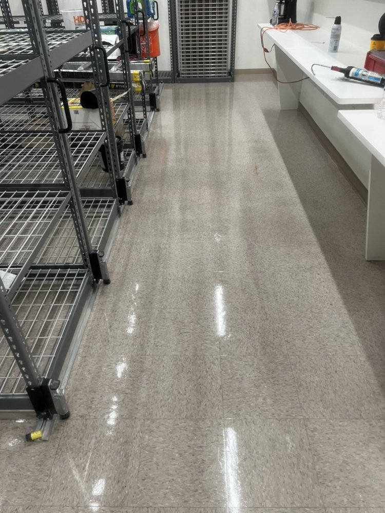 Storeroom with wire shelving and a glossy VCT floor reflecting the light